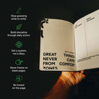 An open notebook or journal for men held in a hand against a dark background, with motivational text printed inside the pages. Green icons and white text on the left side list self-improvement tips such as writing, discipline, a daily diary, and not freezing on blank pages.